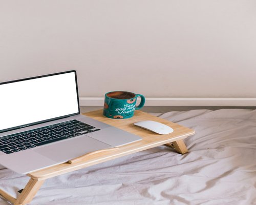 A laptop correctly positioned on a beautiful clean wooden table at eye level